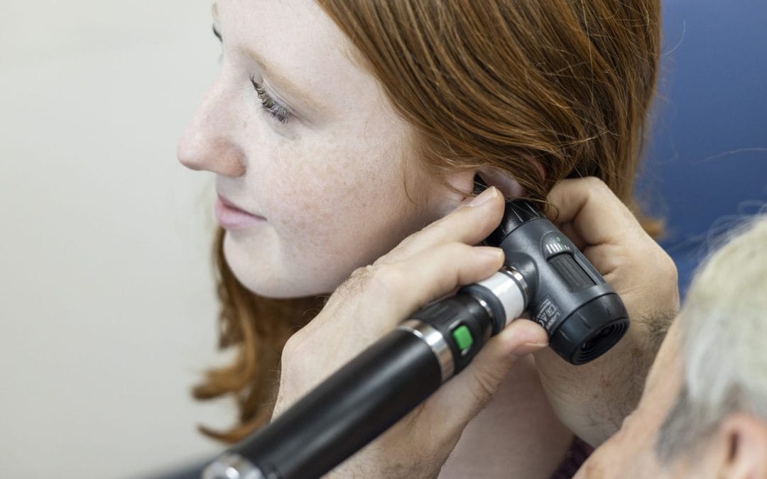 A person with a hearing aid inserted in their ear.